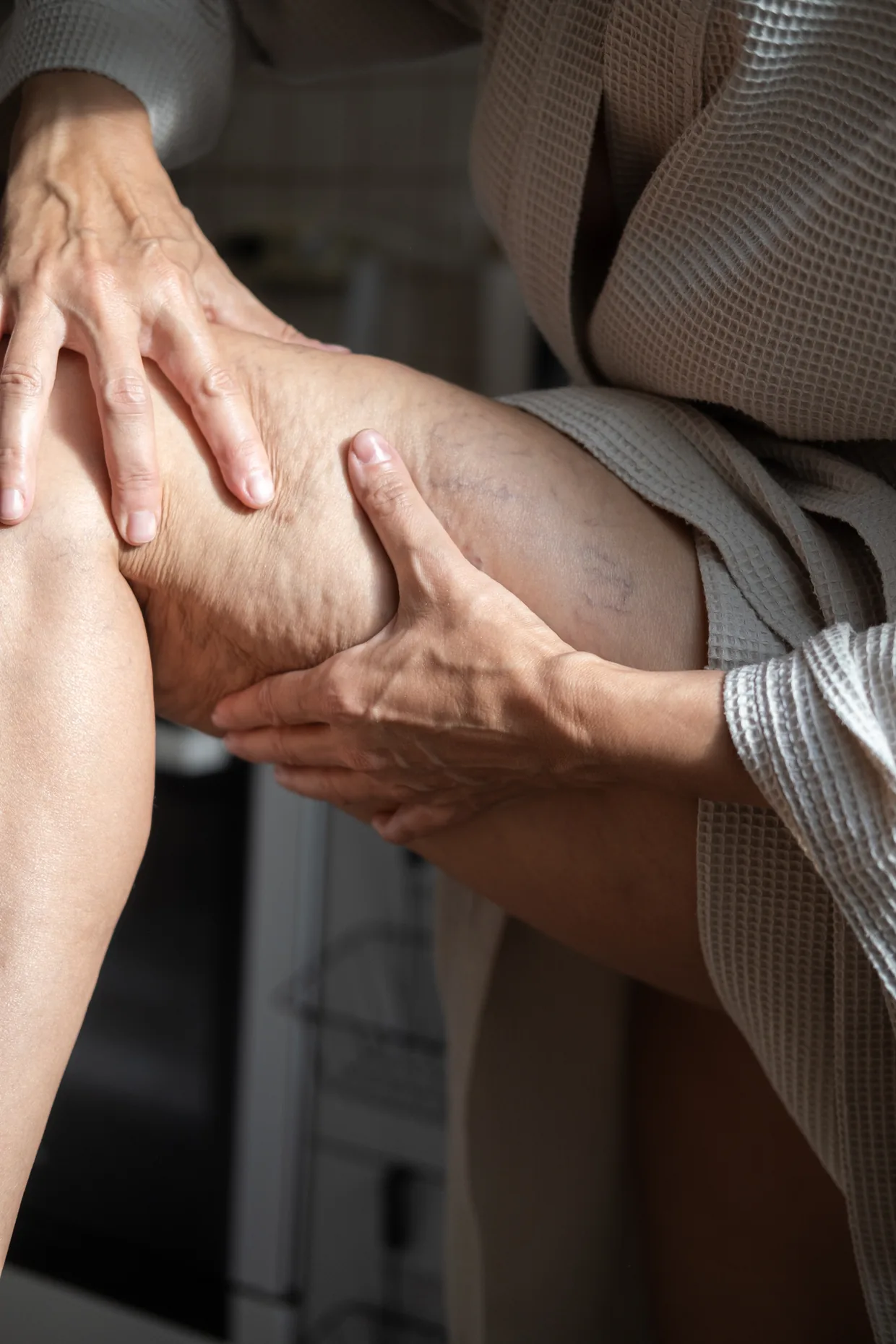 Close-up of hands pressing a swollen calf